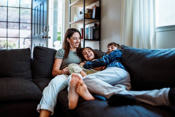 A family is sitting on a couch in a living room.