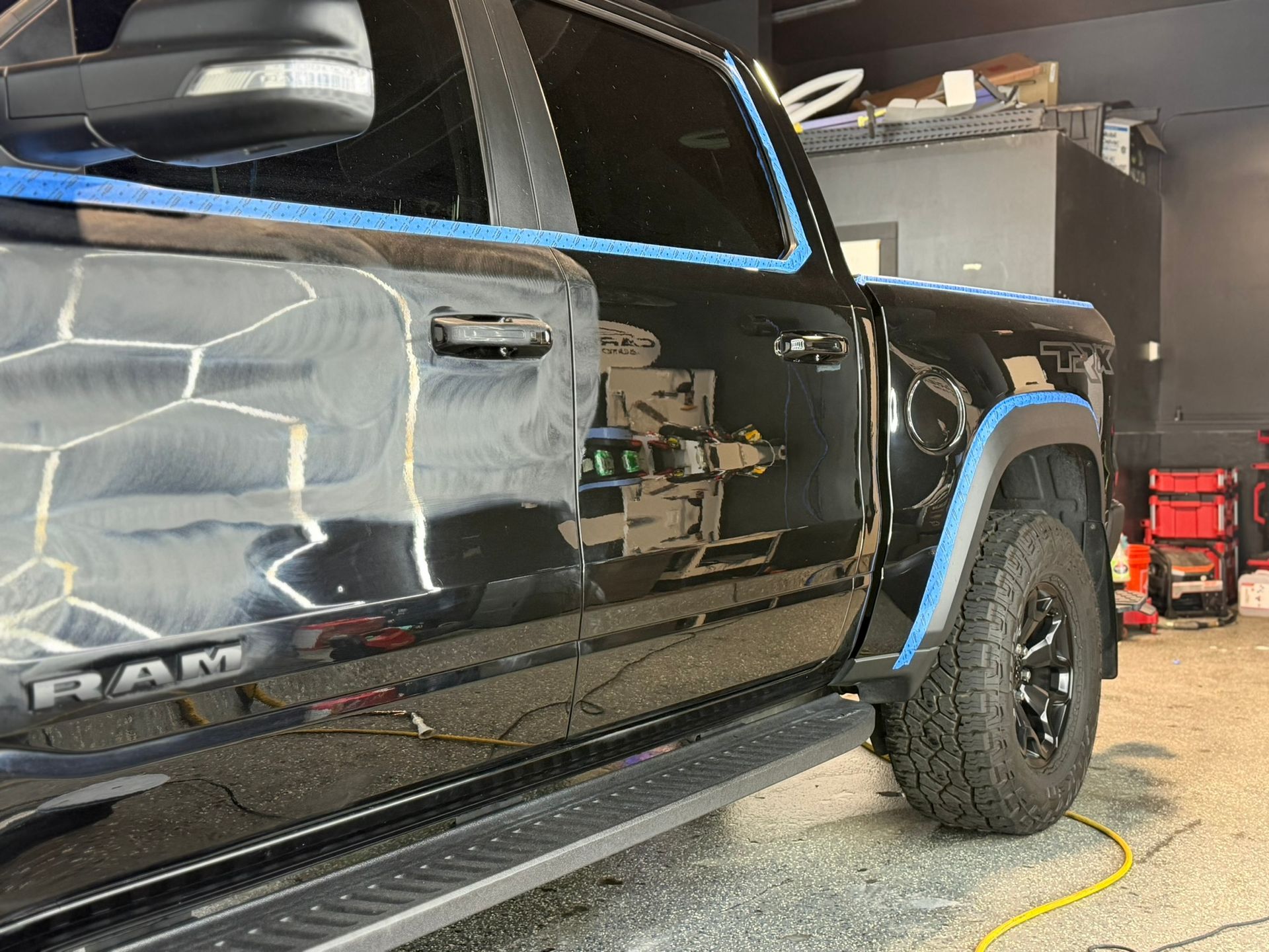 Black truck with yellow tape detailing around the wheel well and bed.