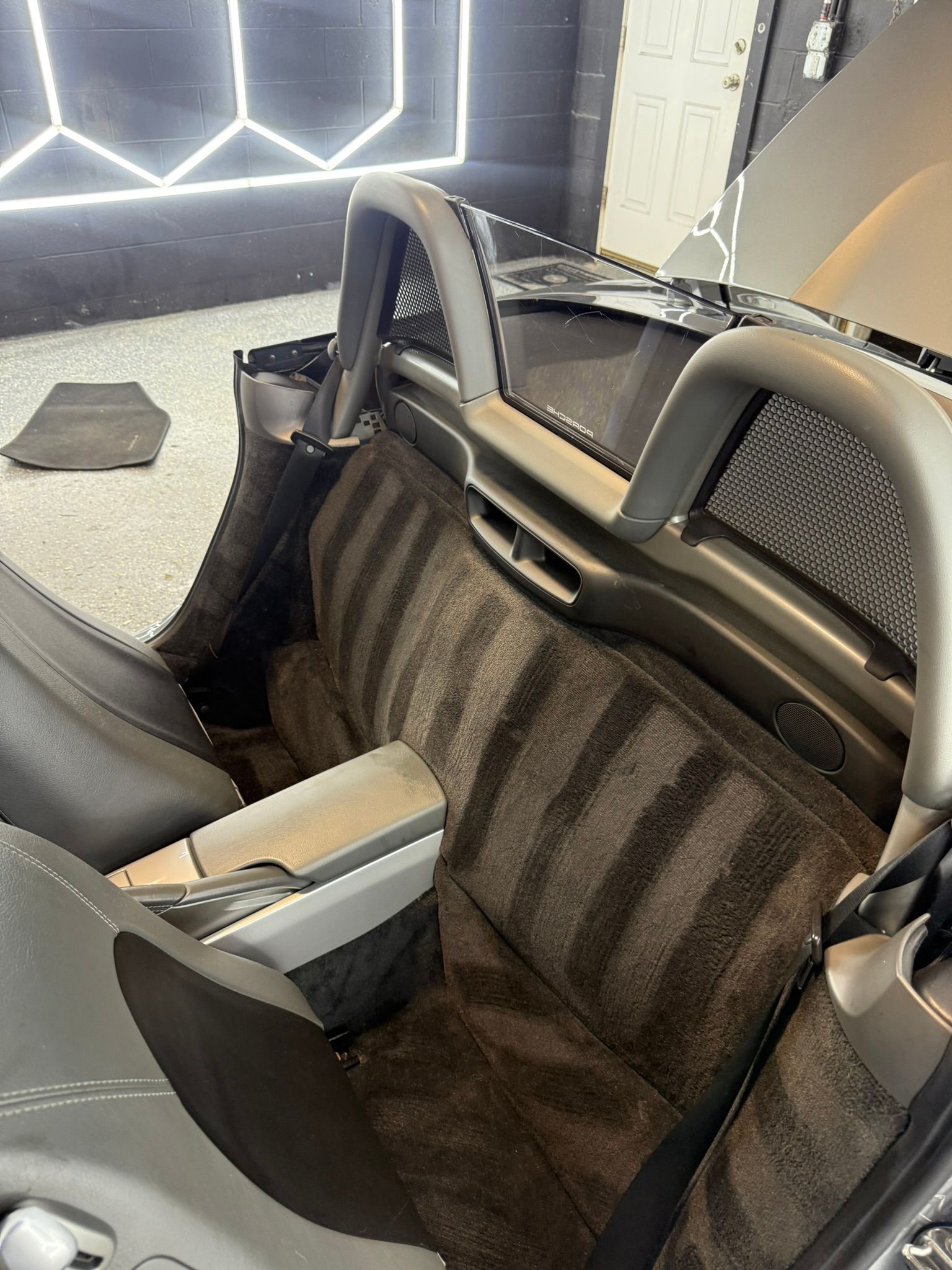 Grey sports car interior with textured seats and roll bar.