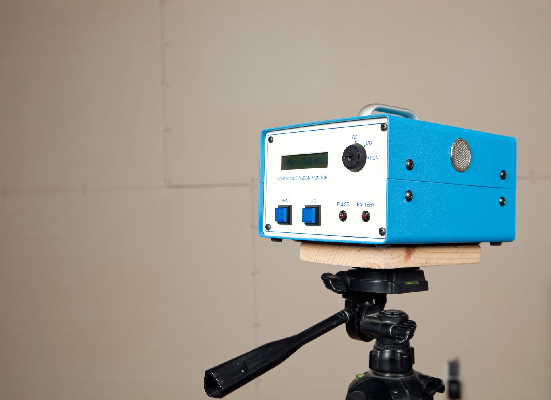 Blue radon monitor device on tripod labeled Continuous Radon Monitor.