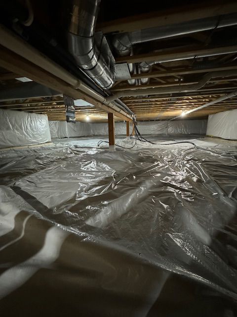 Crawlspace with plastic sheeting on the ground, wood beams, and ductwork visible.