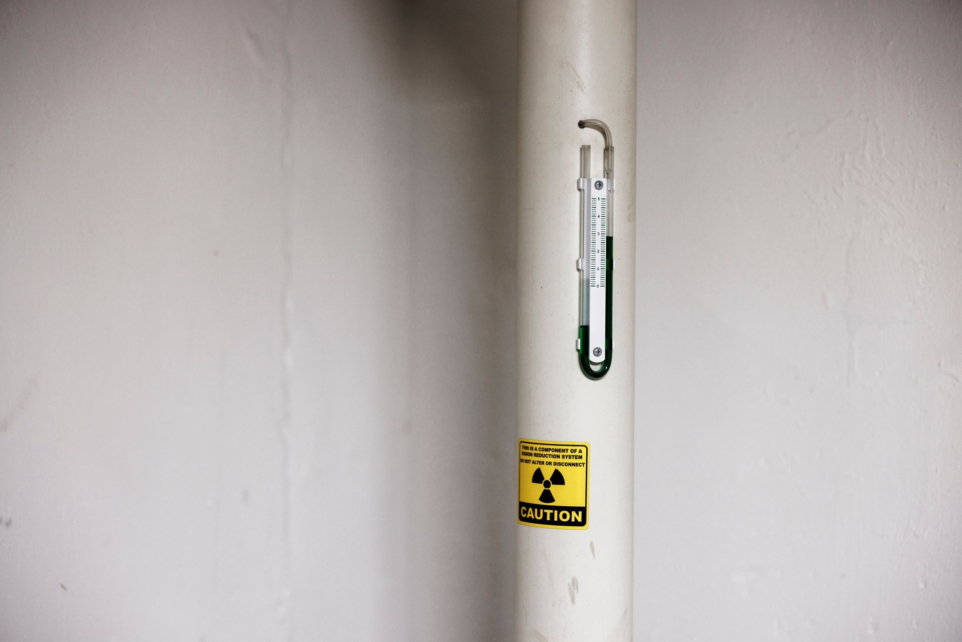 White PVC pipe of radon mitigation system.