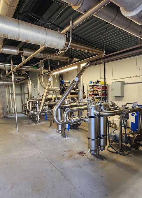 A large room filled with pipes and machinery in a factory.