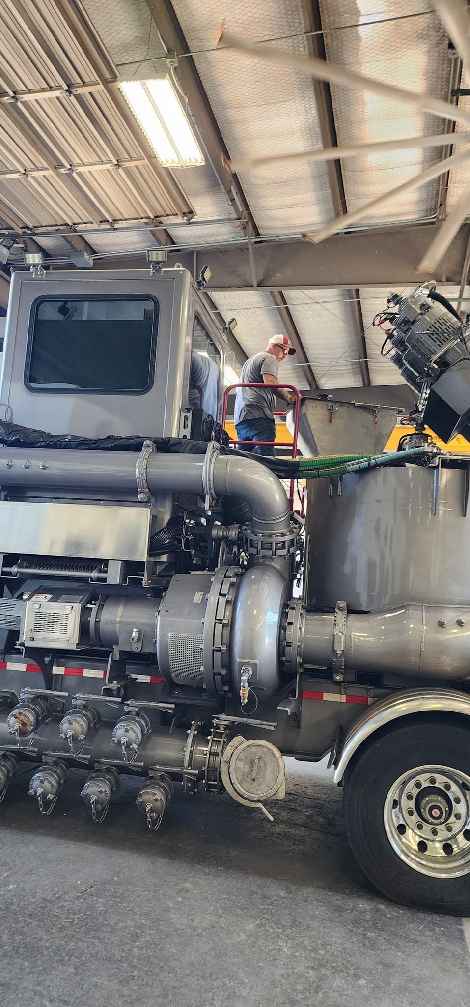 A large tanker truck is parked in a garage.