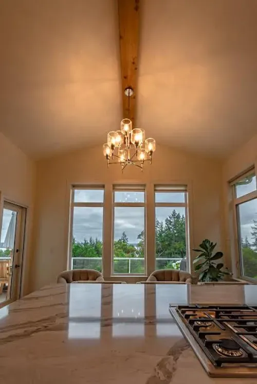A kitchen with a stove top oven and a chandelier hanging from the ceiling.