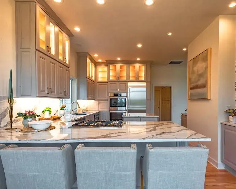 A kitchen with a marble counter top and stainless steel appliances