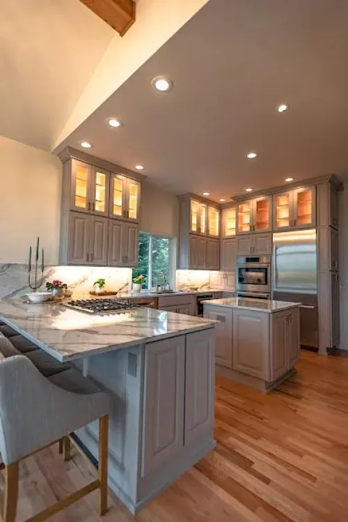A kitchen with a large island and marble counter tops.