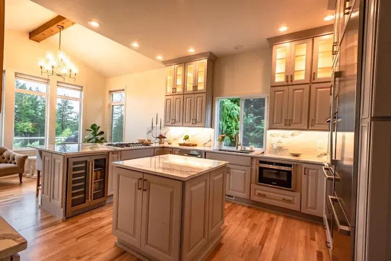 A kitchen with a large island in the middle of it and stainless steel appliances.