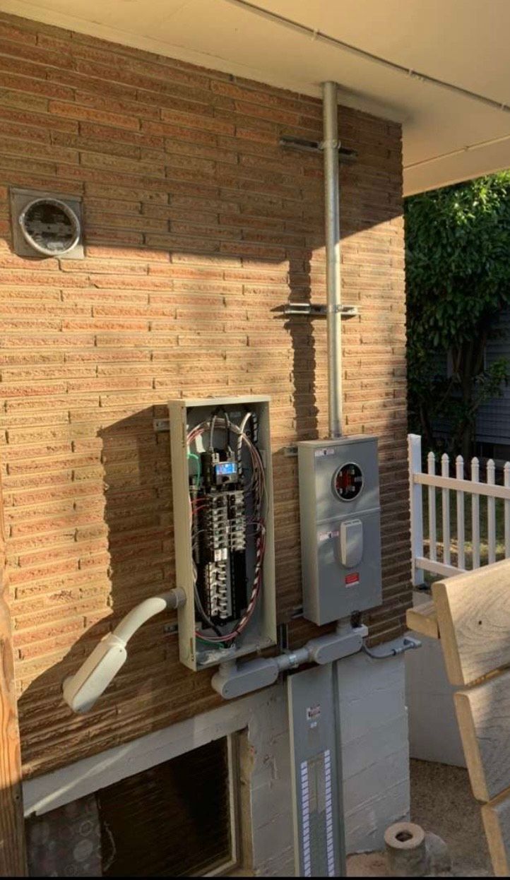 A brick wall with a electrical box on it.