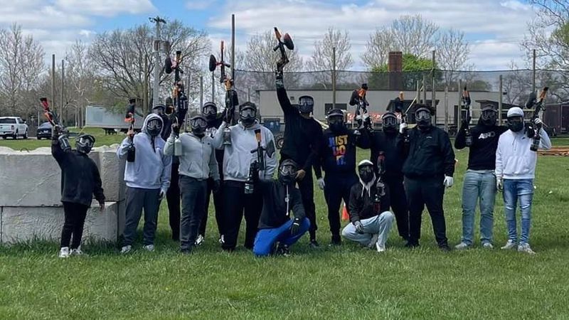 Four people wearing shirts spelling