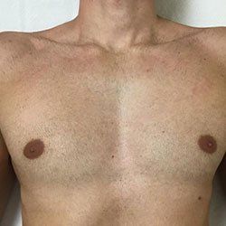 A close up of a man 's chest with no hair on it.