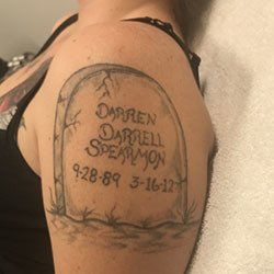 A woman has a tattoo of a gravestone with the name darren on it
