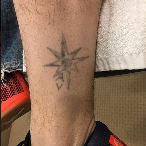 A person 's leg with a tattoo of a star on it.