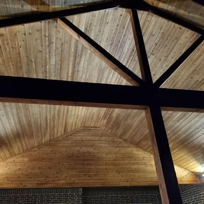 Wooden vaulted ceiling with exposed dark beams and triangular roof panels