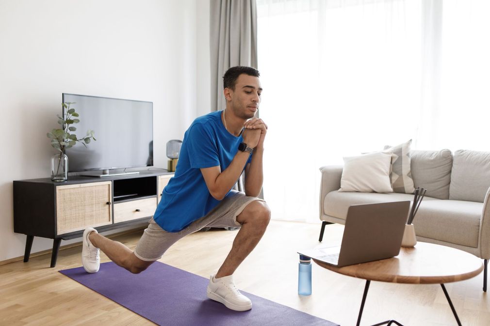 man working out in home with computer