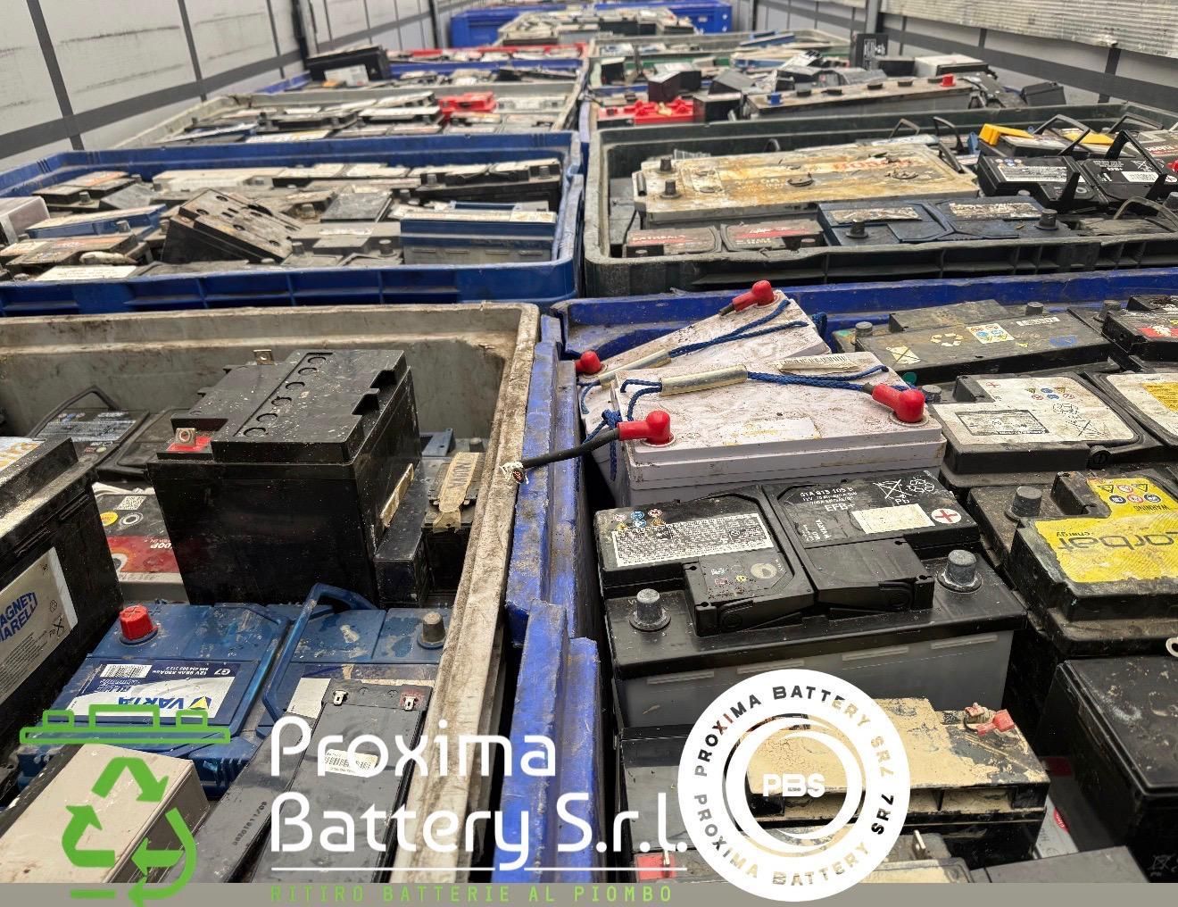 Batterie al piombo usate impilate in grandi contenitori di plastica blu per il riciclaggio presso Proxima Battery SRL