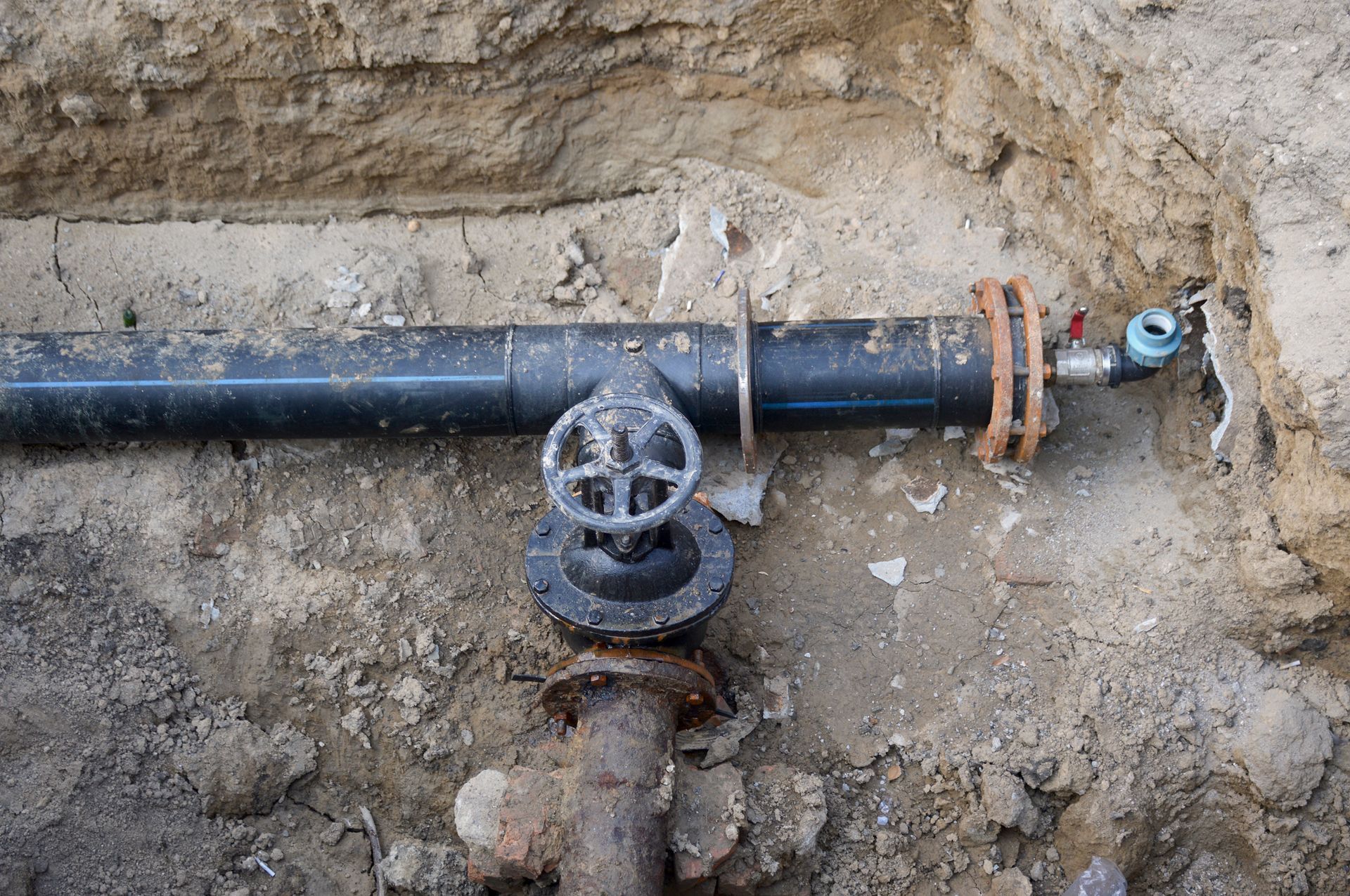 A Black Pipe with a Valve on it is Sitting in the Dirt — Albuquerque, NM — Al's Sewer Service