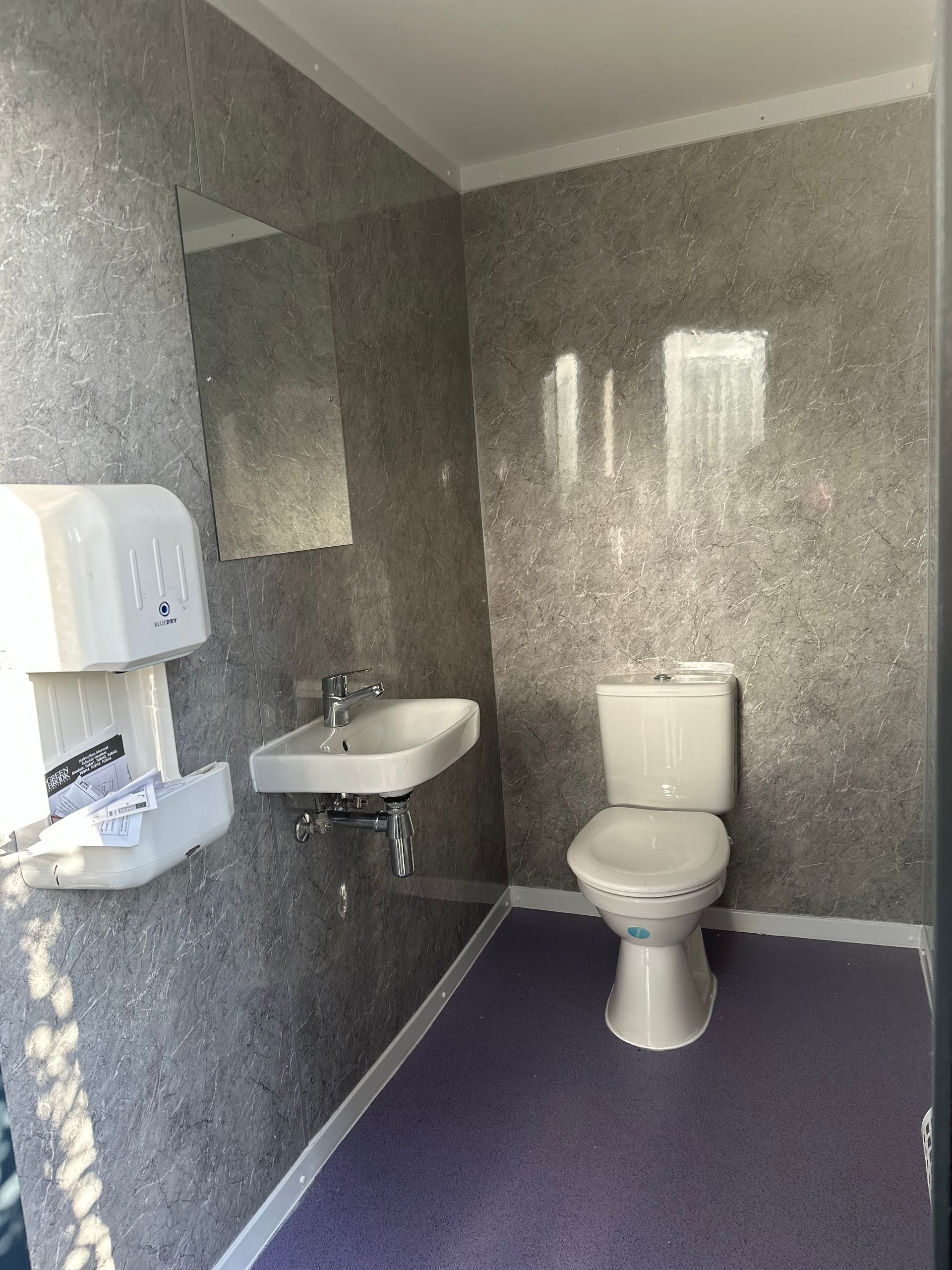 Internal view of single commercial office toilet with laminated panels. 