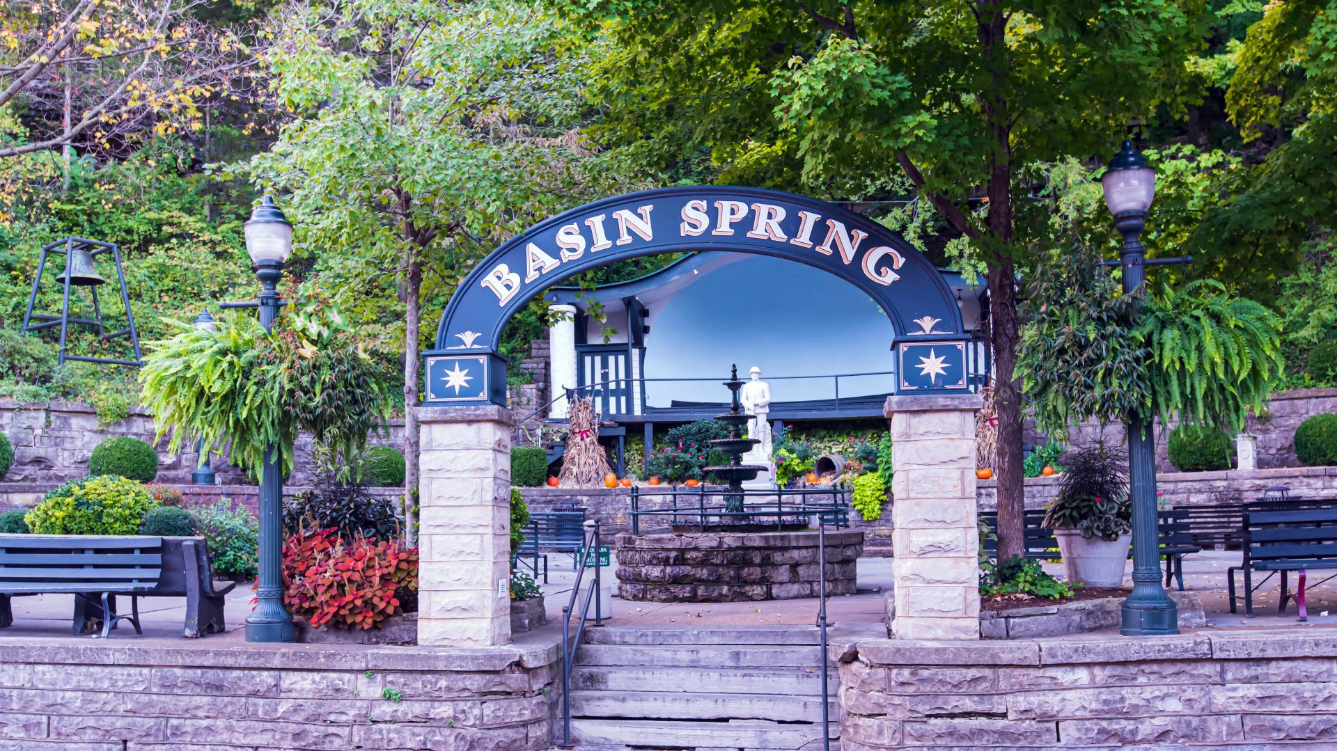 The entrance to basin spring park is surrounded by trees and benches.