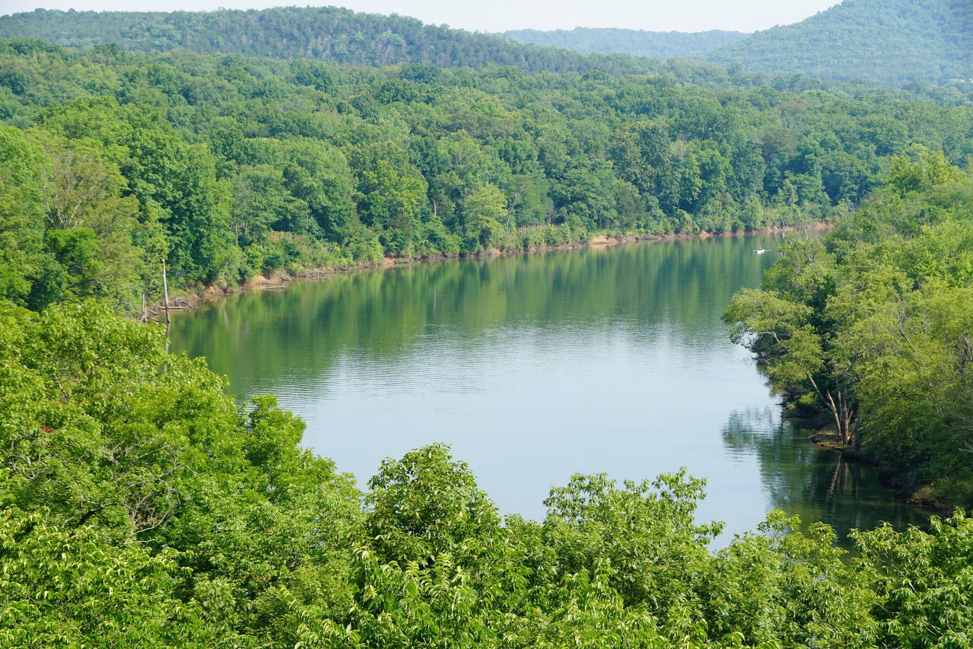 A large body of water surrounded by trees and mountains.
