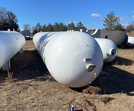 A bunch of white tanks are sitting in a field