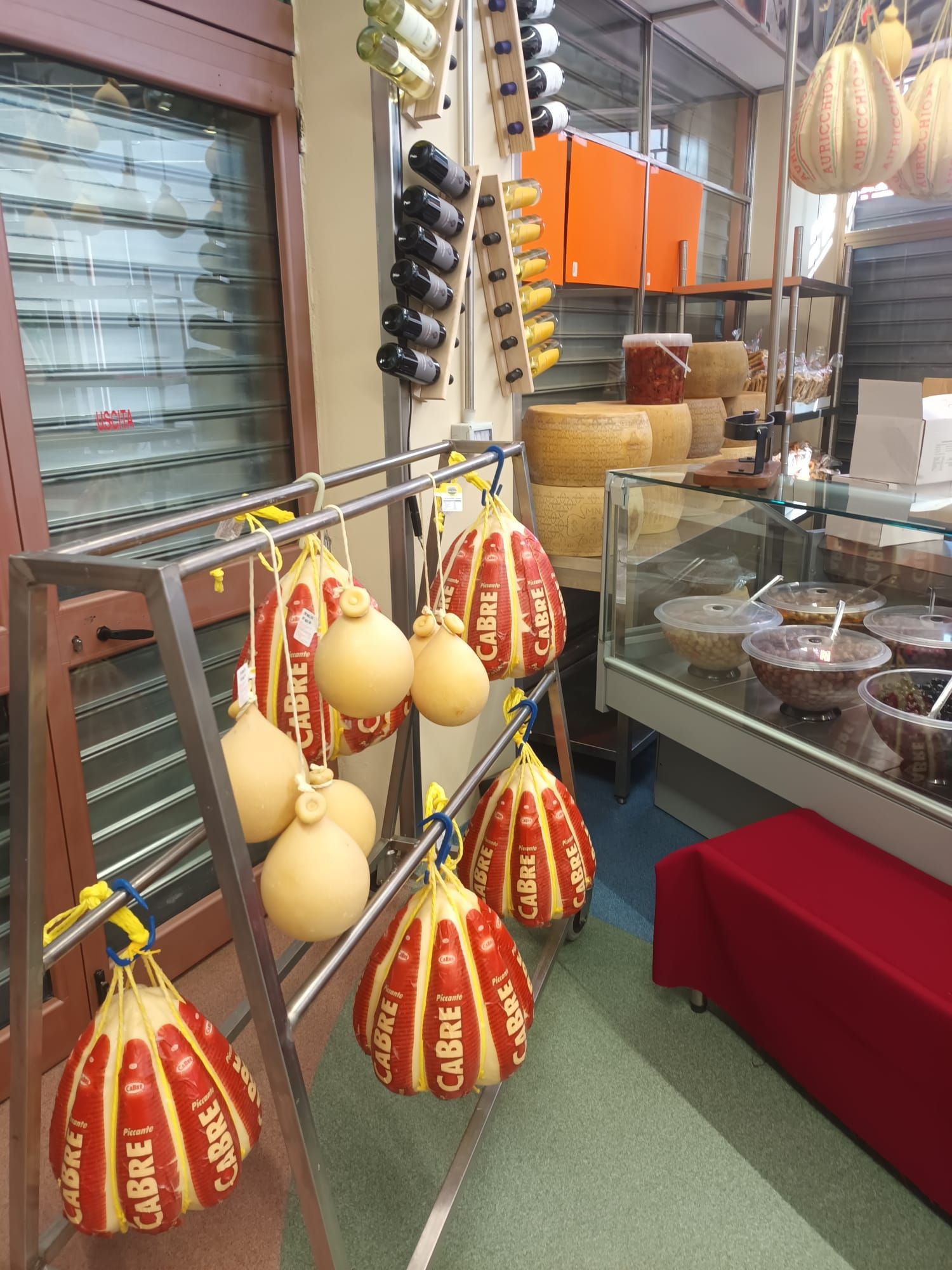 Un mucchio di formaggi è appeso su uno scaffale in un negozio