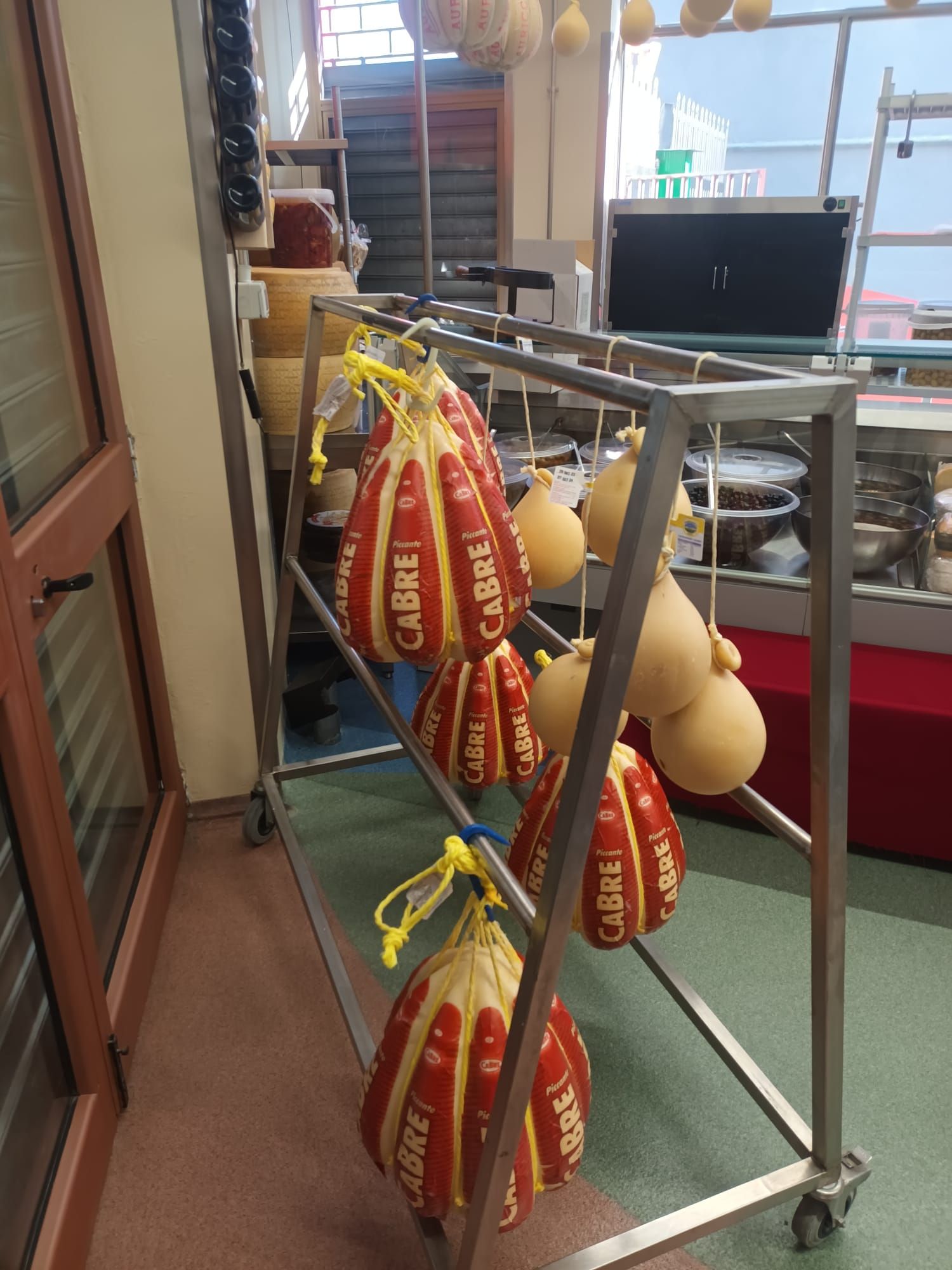 Su una griglia sono appesi dei sacchi di formaggio.