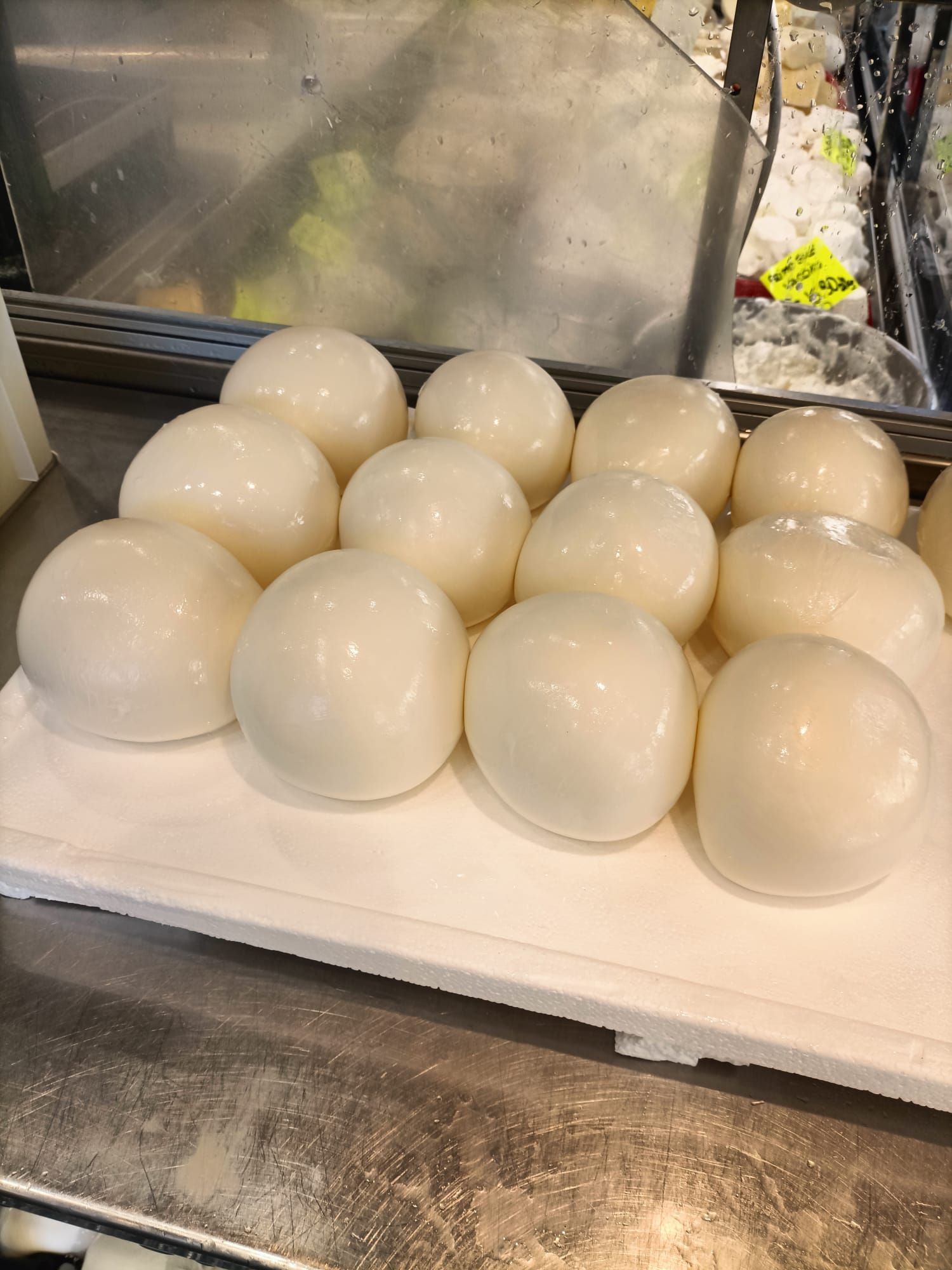 Un mazzo di palline bianche è seduto su un vassoio bianco su un bancone.