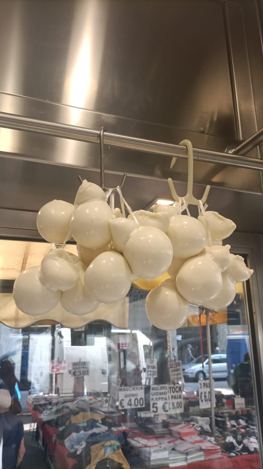 Un mucchio di formaggio è appeso al soffitto di un negozio.