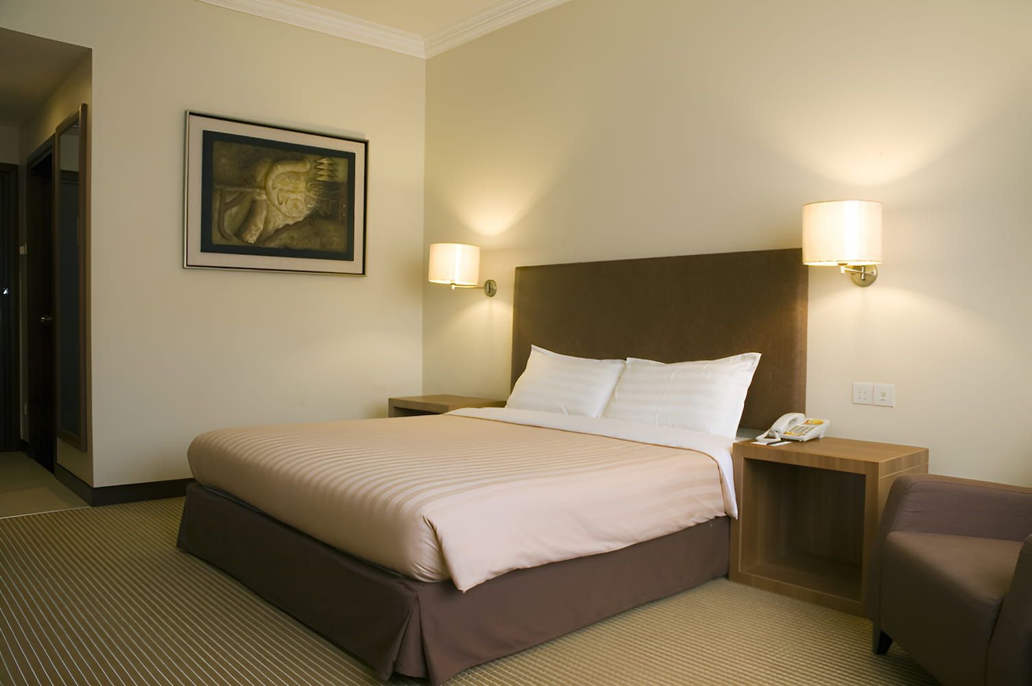 A Hotel Room With a Large Bed and a Chair — Bryants Beds and Mattresses In Lismore, NSW