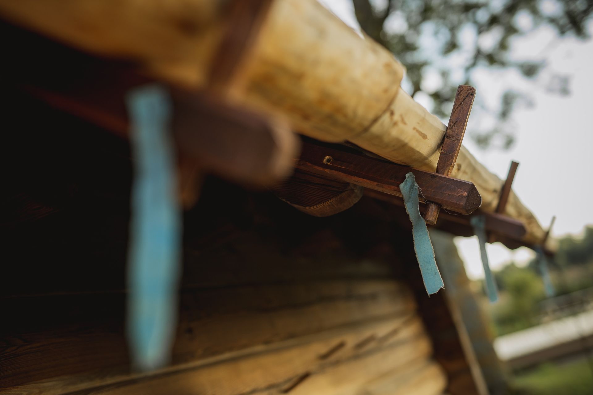 Wooden roof with blue ribbon decorations; outdoors.