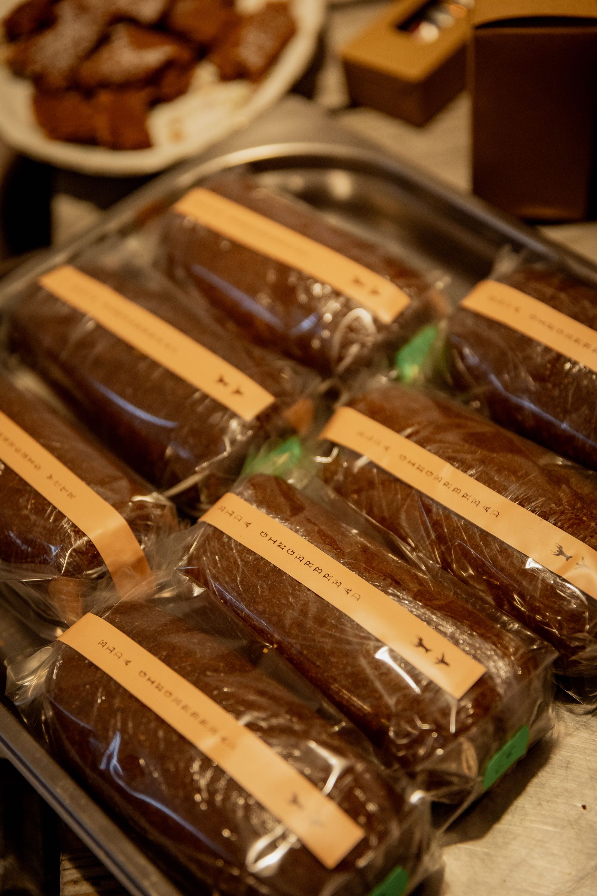 Glass jars of honey on wooden surface, with a blurred background of dried plants.