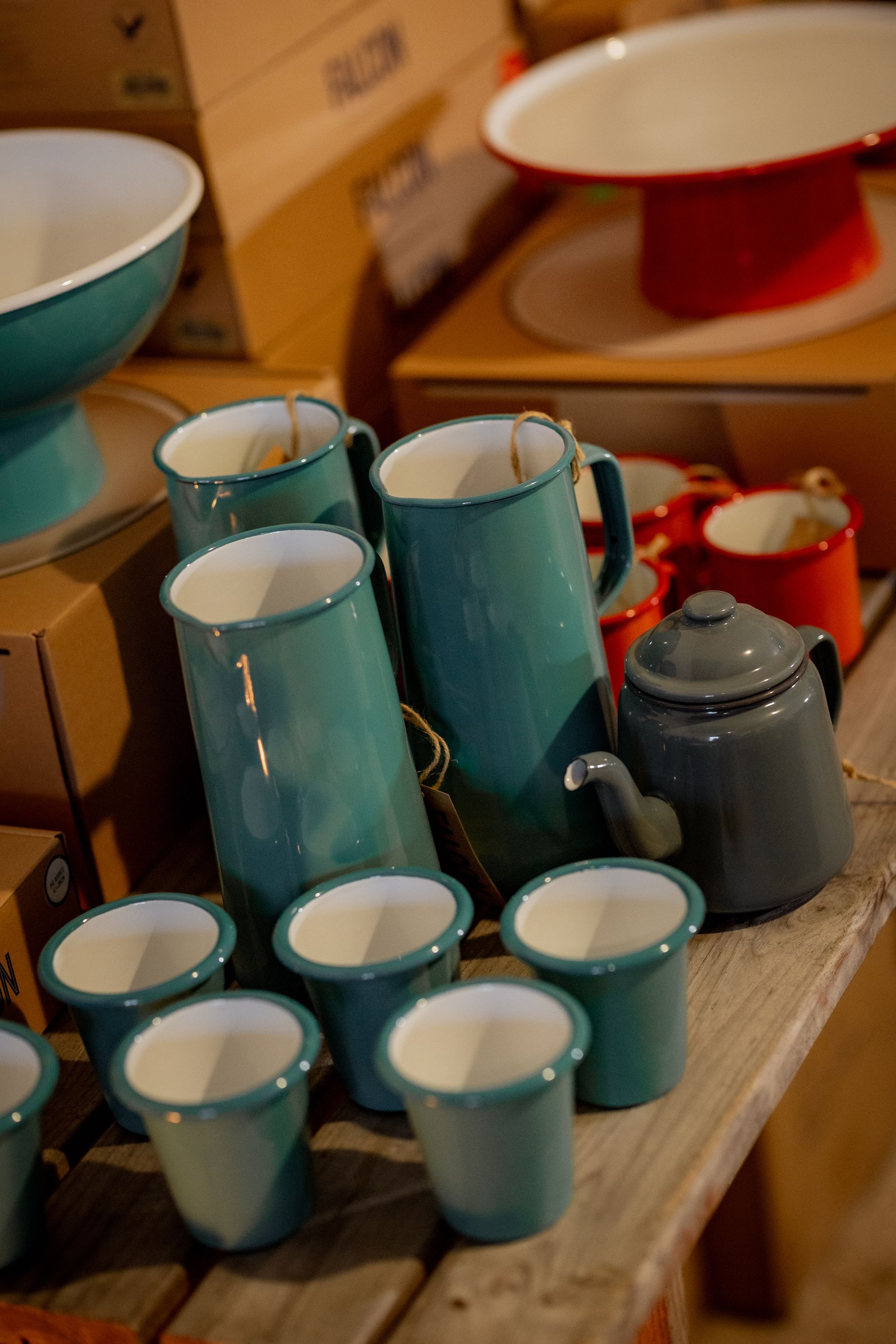 Bottles of dark liquid with colored labels on a wooden table against a neutral background.