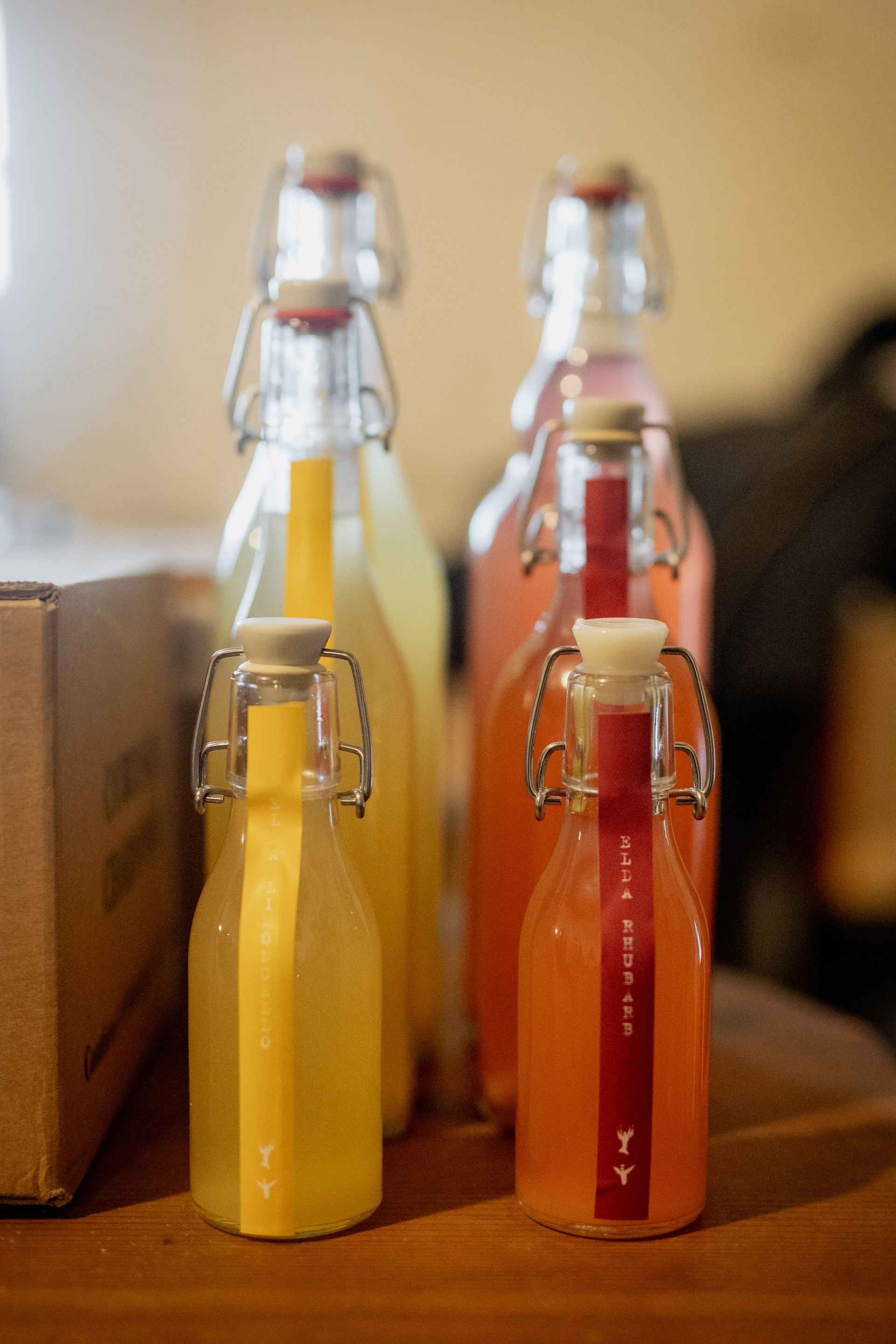 Shelves with dark bottles of wine, varying label colors, and wood background.