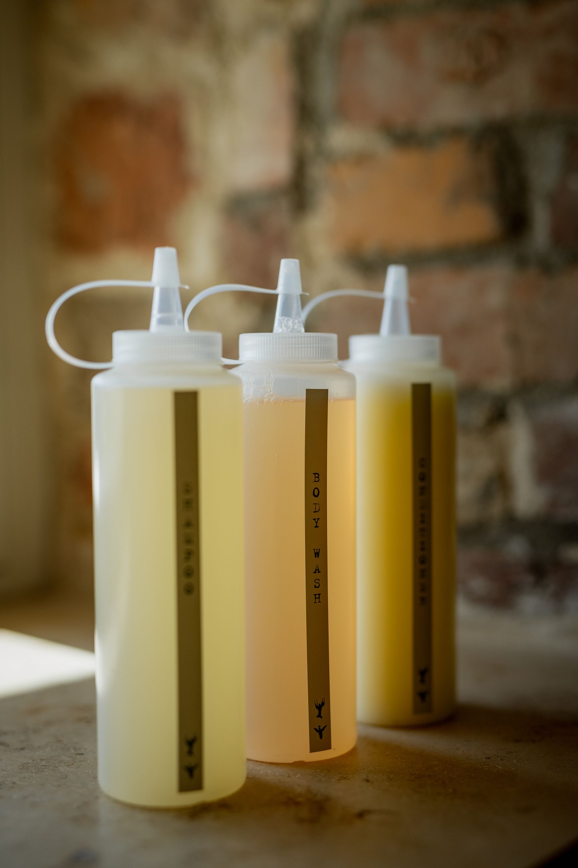 Three squeeze bottles with yellow liquids, labels reading 