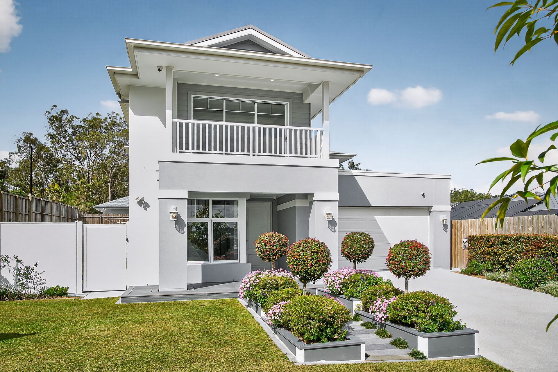 A white house with a white roof and a driveway