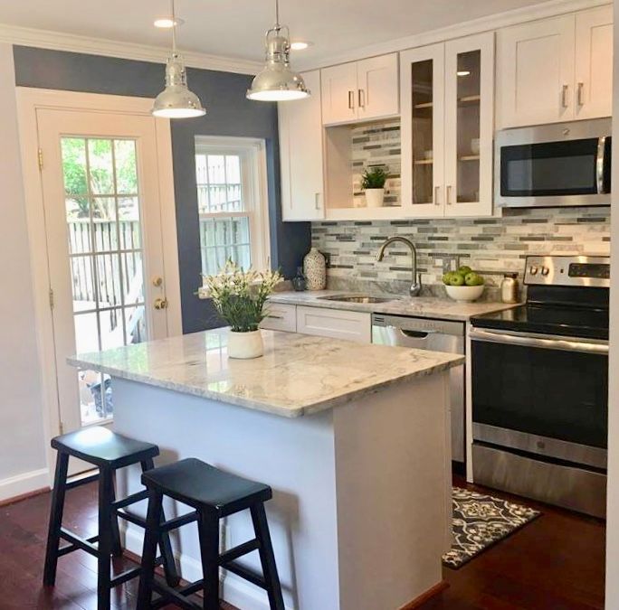 A kitchen with a large island and two stools