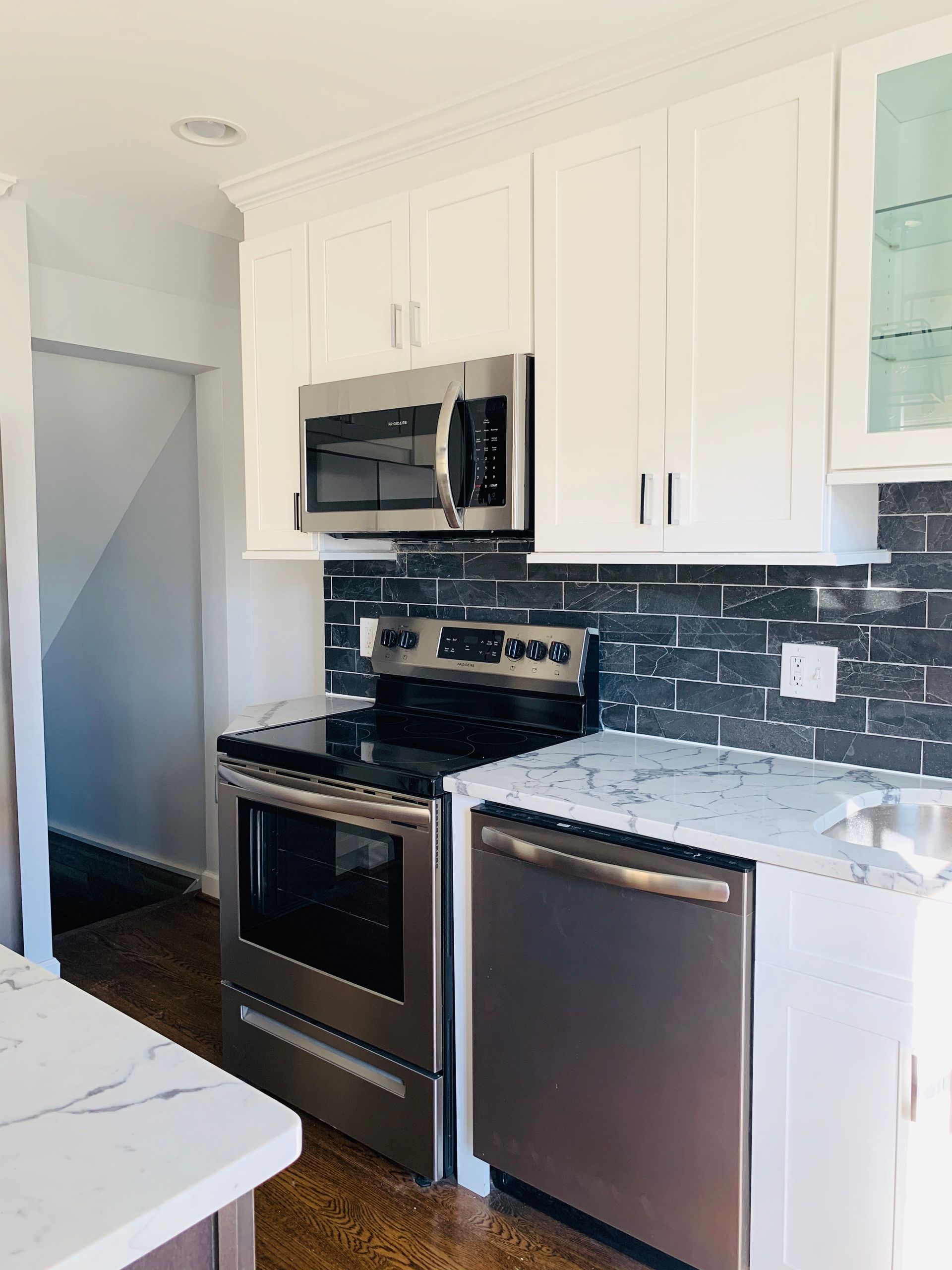 A kitchen with stainless steel appliances and white cabinets