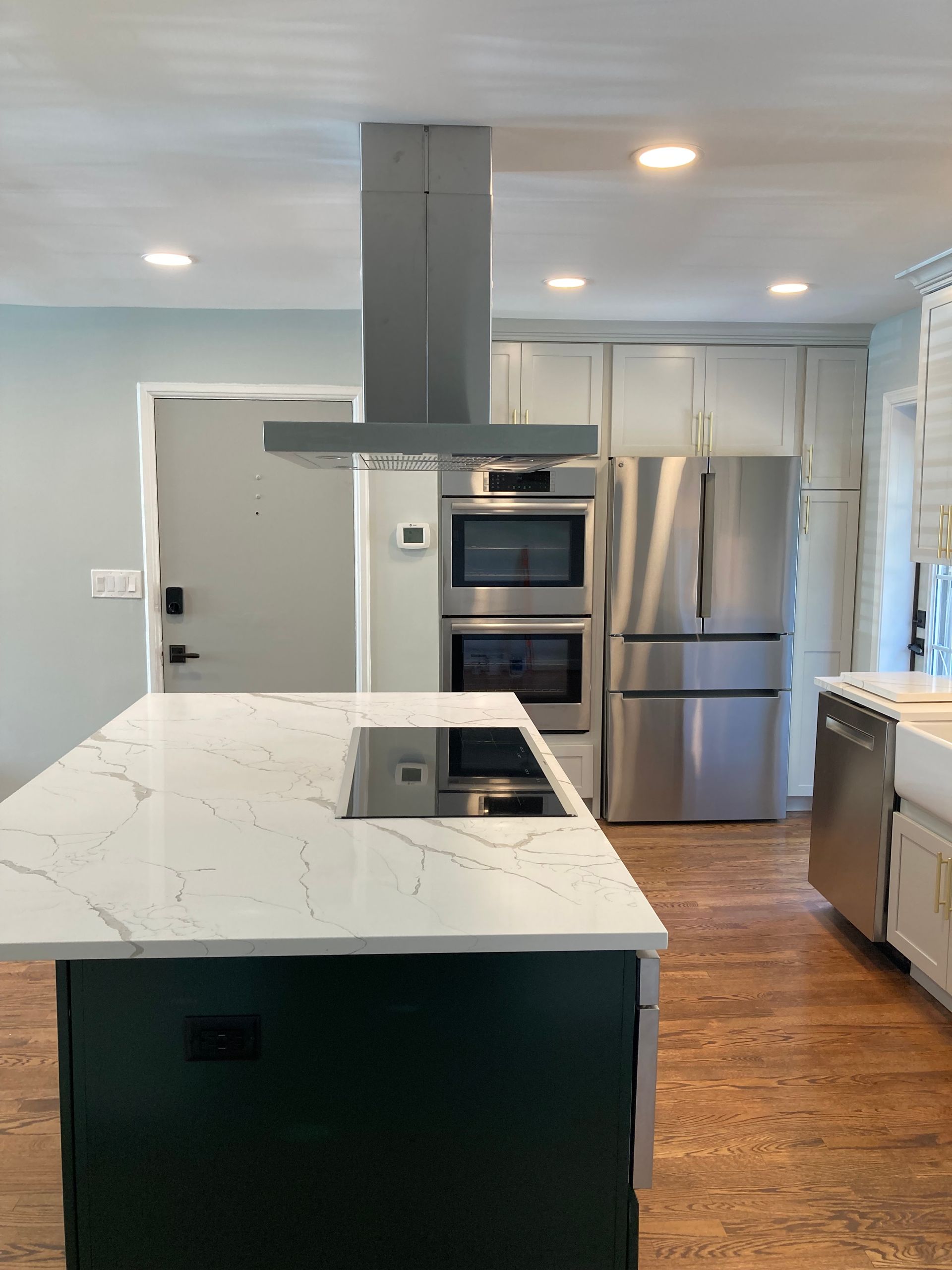 A kitchen with stainless steel appliances and a large island.
