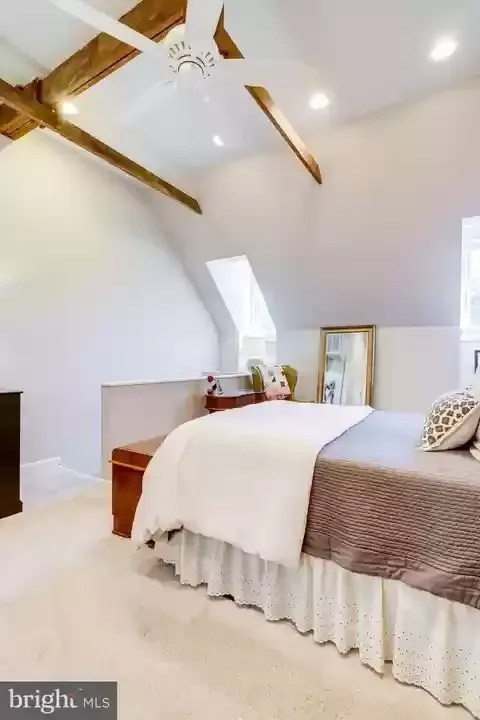 A bedroom with a bed and a ceiling fan.