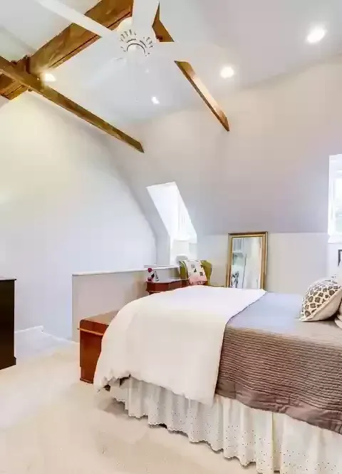 A bedroom with a large bed and a ceiling fan.