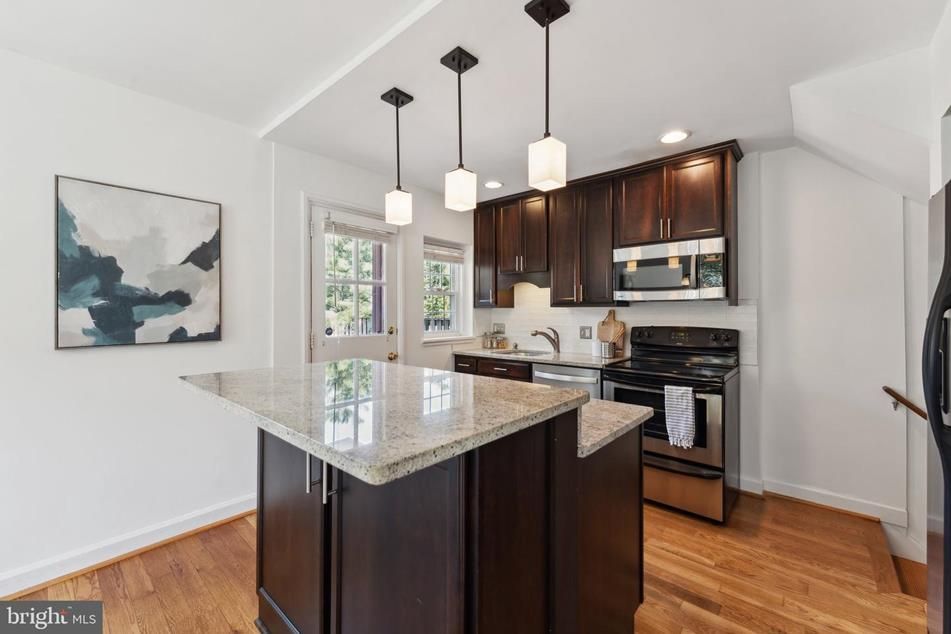 A kitchen with a large island and stainless steel appliances.