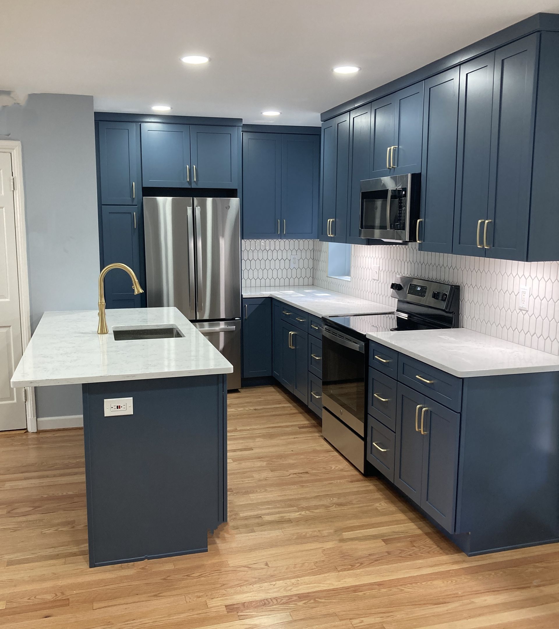 A kitchen with blue cabinets and stainless steel appliances