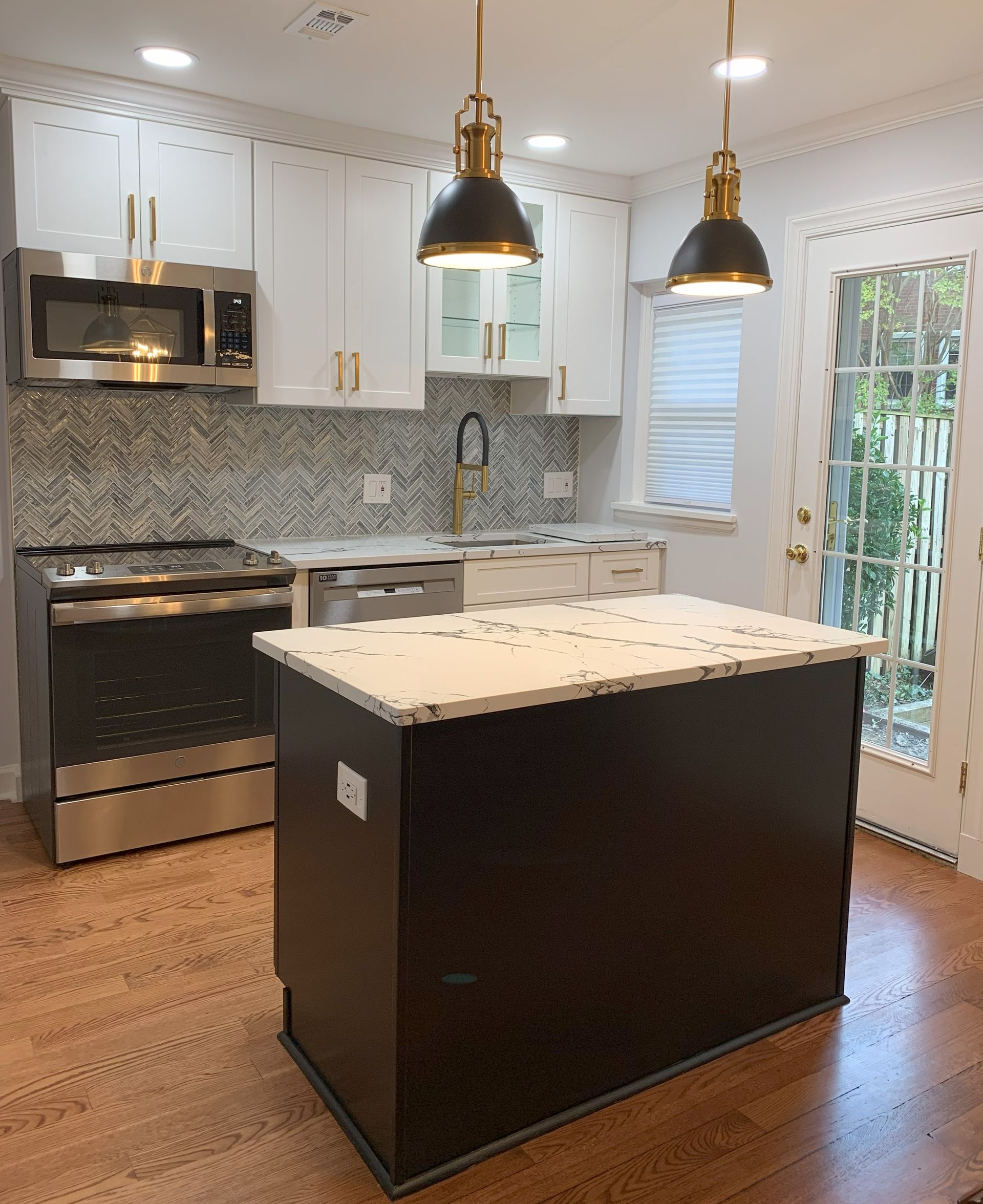 A kitchen with a large island and stainless steel appliances