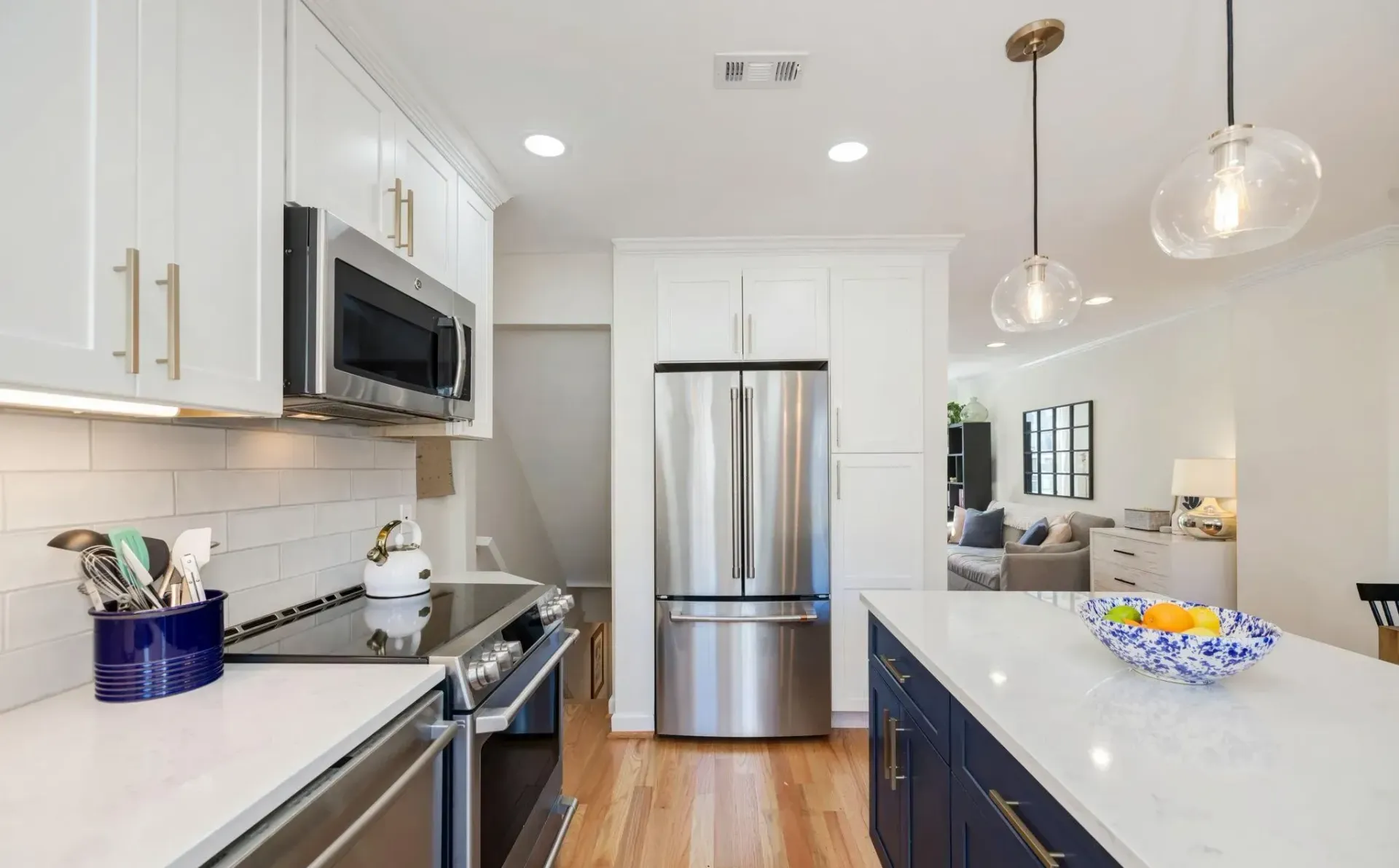 A kitchen with stainless steel appliances and white cabinets.