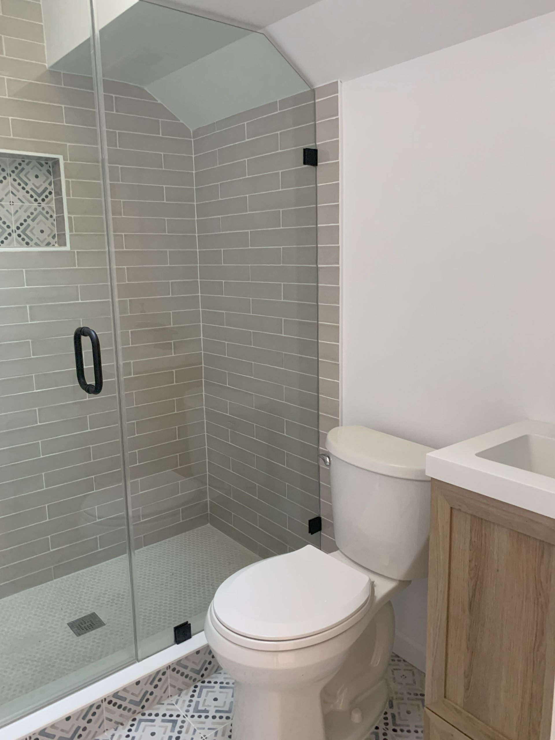 A bathroom with a toilet , sink and shower.