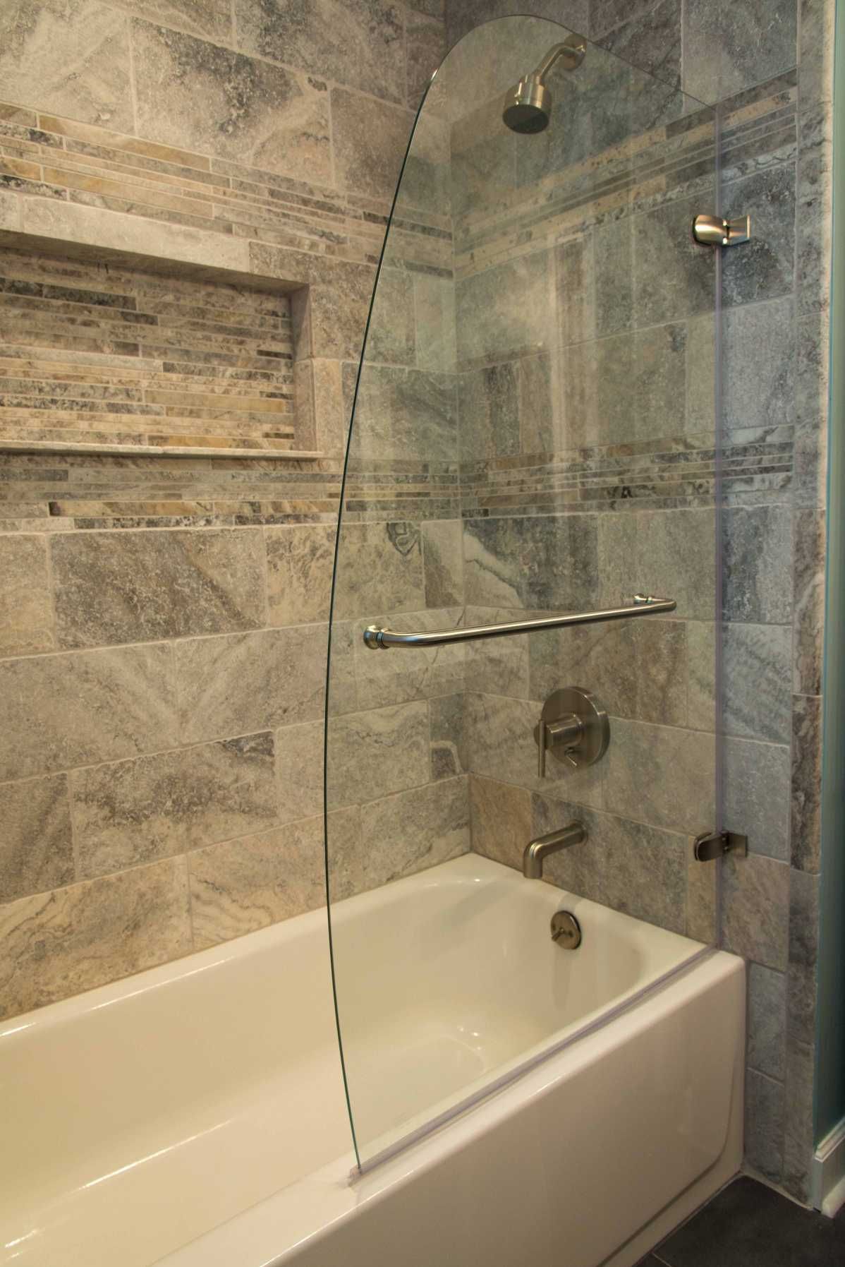 A bathroom with a bathtub and a shower with a glass door.