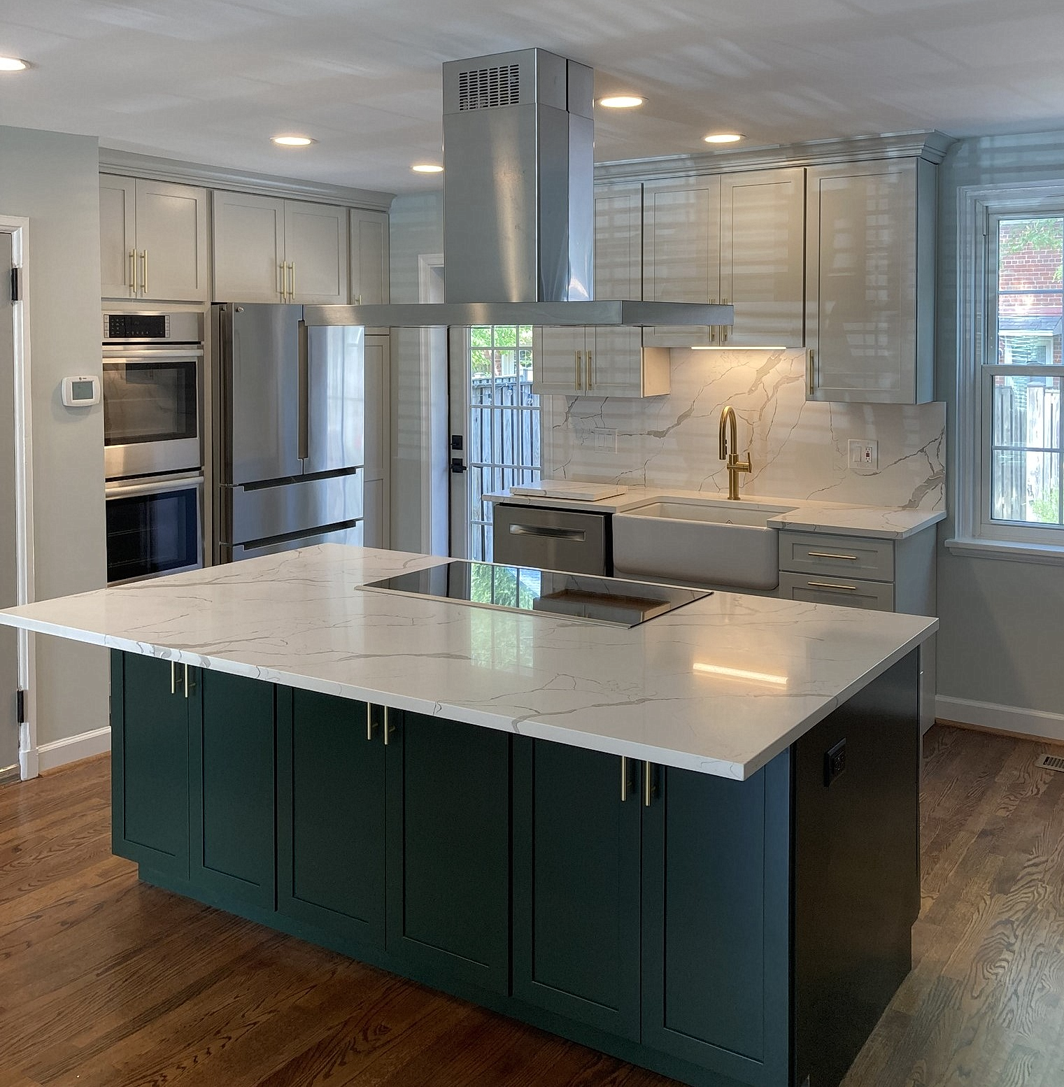A kitchen with green cabinets and white counter tops