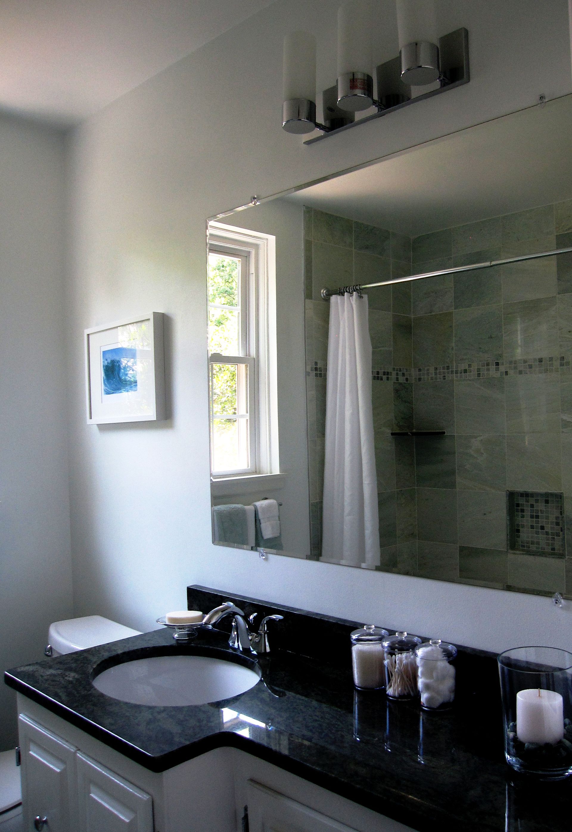 A bathroom with a sink and a large mirror