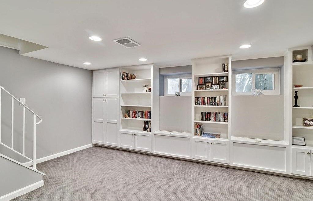 A basement with a lot of shelves and a staircase.